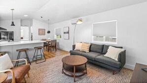 A modern living room with a grey sofa, wooden coffee table, and a patterned rug. - Modern Cabin (Blue Spruce) (Dunsmuir)