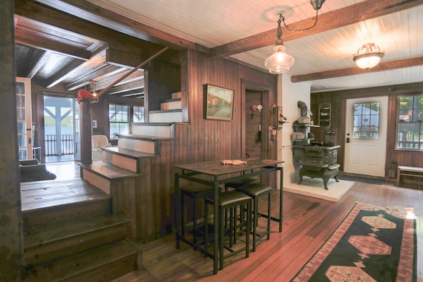 Ein Holzinterieur mit Treppe, Bar und Seeblick durch eine Tür.