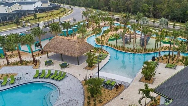 A resort with multiple swimming pools, lounge areas, and a thatched-roof pavilion.