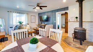 Una sala de estar moderna con comedor, chimenea y televisor.