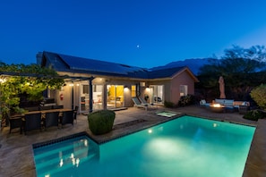 Ein modernes Haus mit Swimmingpool, Sitzgelegenheit im Freien und einer Terrassenfläche.