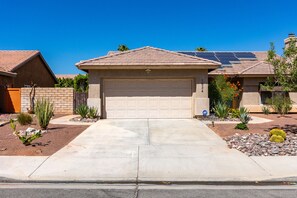 Ein Wohnhaus mit Garage, Solaranlage und gepflegtem Garten.