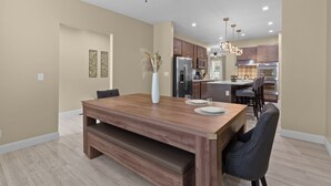A modern kitchen with wooden cabinets, stainless steel appliances, and pendant lighting. - Red Brick Hideaway | JZ Vacation Rentals (St. Louis)