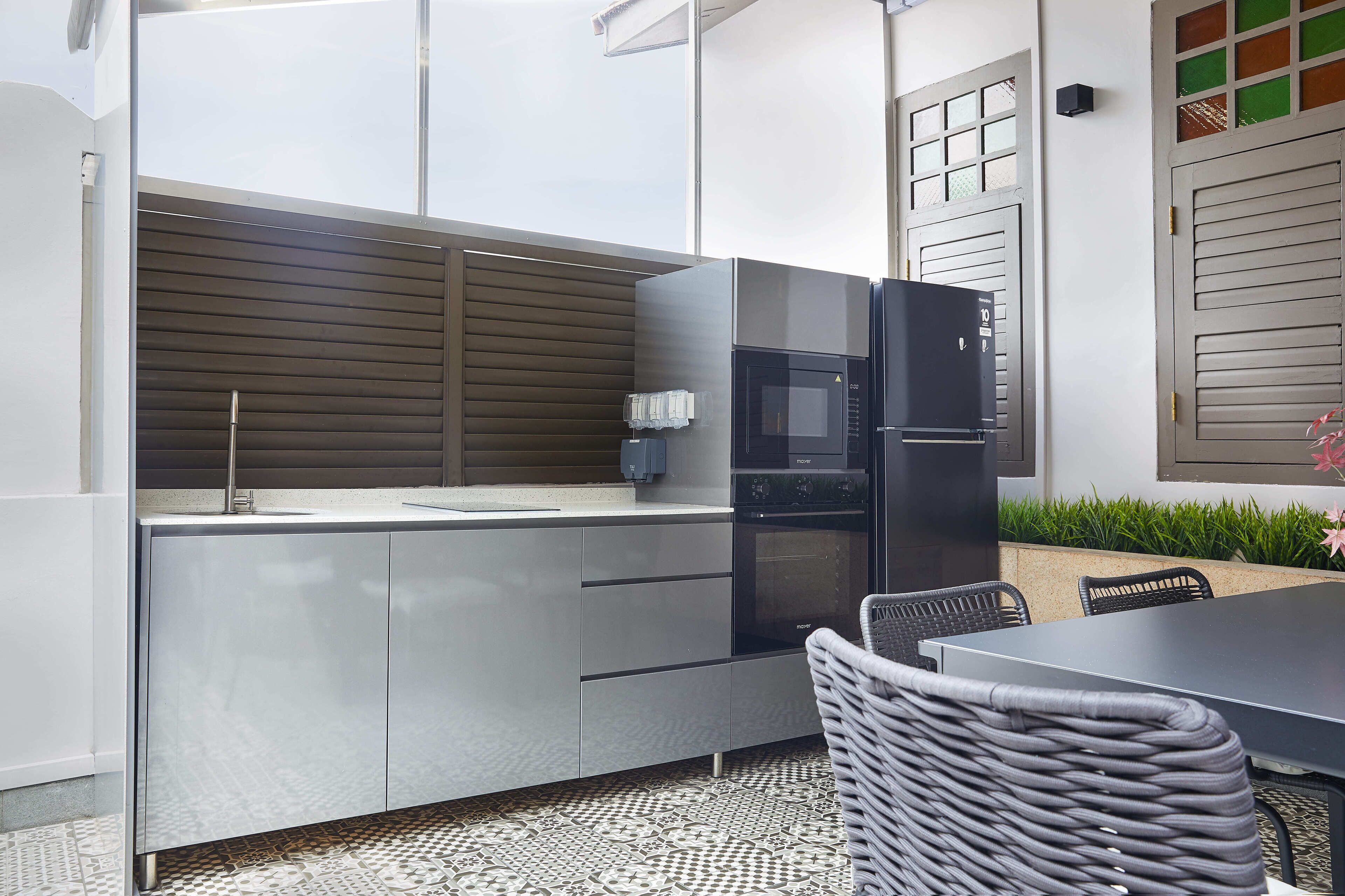 A modern kitchen with a built-in microwave, a sink, and a dining area with a table and chairs.