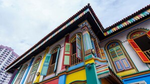 Un edificio colorato con elementi architettonici tradizionali, tra cui finestre decorate e un tetto in tegole.