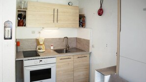 A compact kitchen with a built-in oven, a coffee maker, and a sink. - Lovely 4-person studio with ski in ski out (LES ORRES 1650)