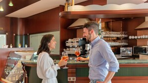 Un espace bar comprenant un comptoir, une vitrine réfrigérée et une machine à café.