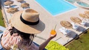 Un espace piscine avec des chaises longues et des parasols.