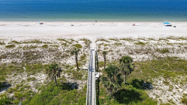 A beach with a white sandy shore, a clear blue sky, and a calm sea. - "SALT WIND" HAS GULF VIEWS, STEPS TO BEACH, SECLUDED & PEACEFUL! (Mexico Beach)