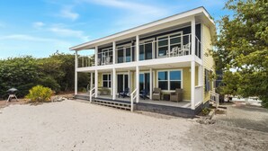 A two-story beachfront house with a balcony, outdoor seating, and a barbecue grill. - "SALT WIND" HAS GULF VIEWS, STEPS TO BEACH, SECLUDED & PEACEFUL! (Mexico Beach)