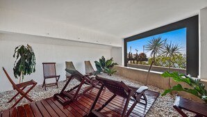 A balcony with wooden furniture, white pebbles, and potted plants. - Suite 2 - Casa Samo Conchas Chinas (Puerto Vallarta)