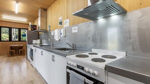 Een moderne keuken met roestvrijstalen apparatuur, houten kasten en een raam met uitzicht op de omgeving.