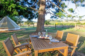 A wooden table set outdoors with a tent in the background. - Forrest Holiday Park (Forrest)