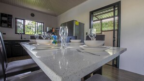 Een moderne keuken met een groot kookeiland, voorzien van een spoelbak, fornuis en veel aanrechtruimte.