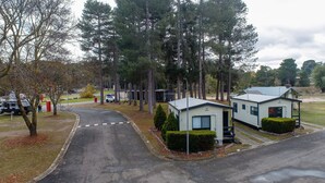 A campground with mobile homes, a paved road, and surrounding trees. - Creswick Holiday Park (Creswick)