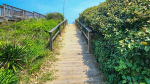 A wooden pathway with railings leading to a beach area. - Seas The Day - Oceanside 4 BR Home w/Private Pool - Short walk to shops/restaurants (Duck)