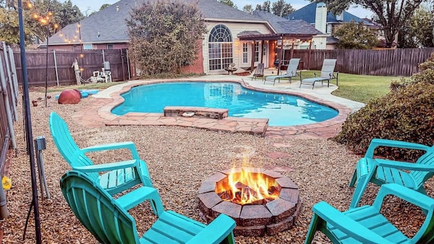 A backyard with a swimming pool, fire pit, and outdoor seating. - Villa with Pool, BBQ and More (Flower Mound)