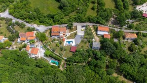 An aerial view of a residential area with multiple houses, a swimming pool, and a road. - Gorgeous apartment in Malinska with swimming pool (Malinska)