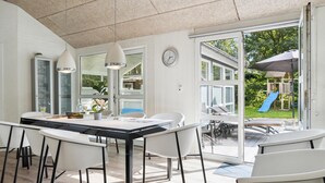 A modern dining area with a glass door leading to an outdoor patio. - Beautiful home in Glesborg with sauna (Glesborg)