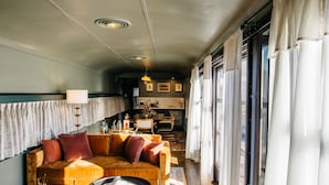 Un salon confortable avec un canapé, une table basse et un coin repas comprenant des chaises et une table.