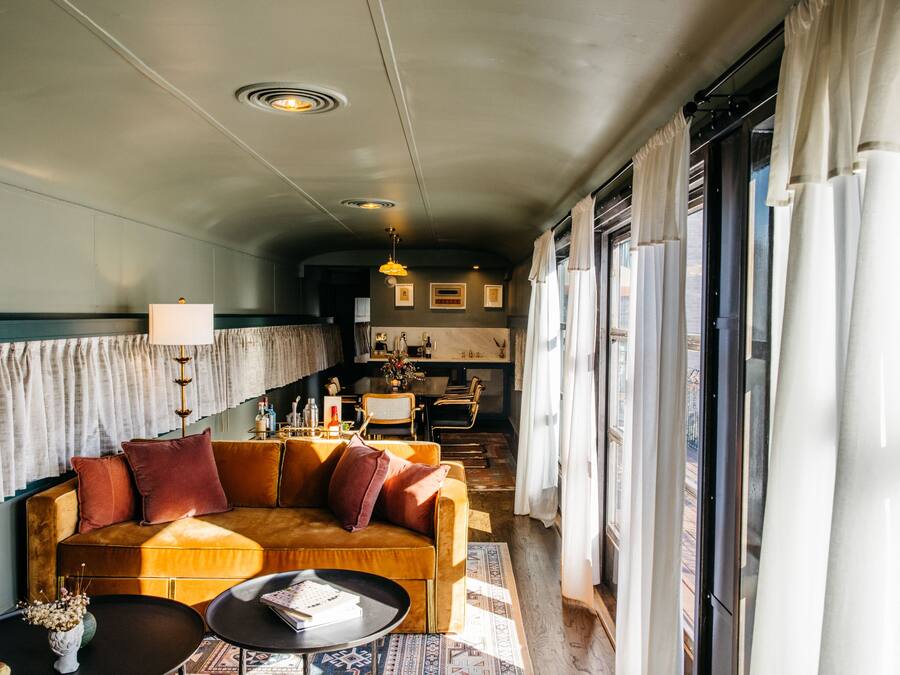 A cozy living room with a sofa, coffee table, and a dining area with chairs and a table.