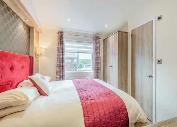 Una habitación de hotel con cama, ventana, armario y puerta.