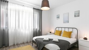 Une chambre à coucher moderne avec un lit, des tables de chevet et une commode.