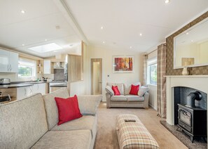 A modern living room with a sofa, ottoman, and a fireplace.