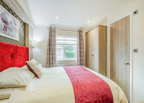 Une chambre à coucher avec un lit, des rideaux, une fenêtre et une porte.