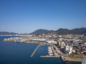 Un paisaje urbano costero con un puerto deportivo, edificios industriales y zonas residenciales.