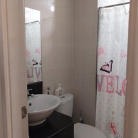 A bathroom with a white sink, toilet, and shower curtain with a butterfly design.