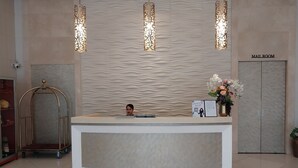 Una recepción con diseño moderno, un letrero que indica sala de correo y una planta decorativa.