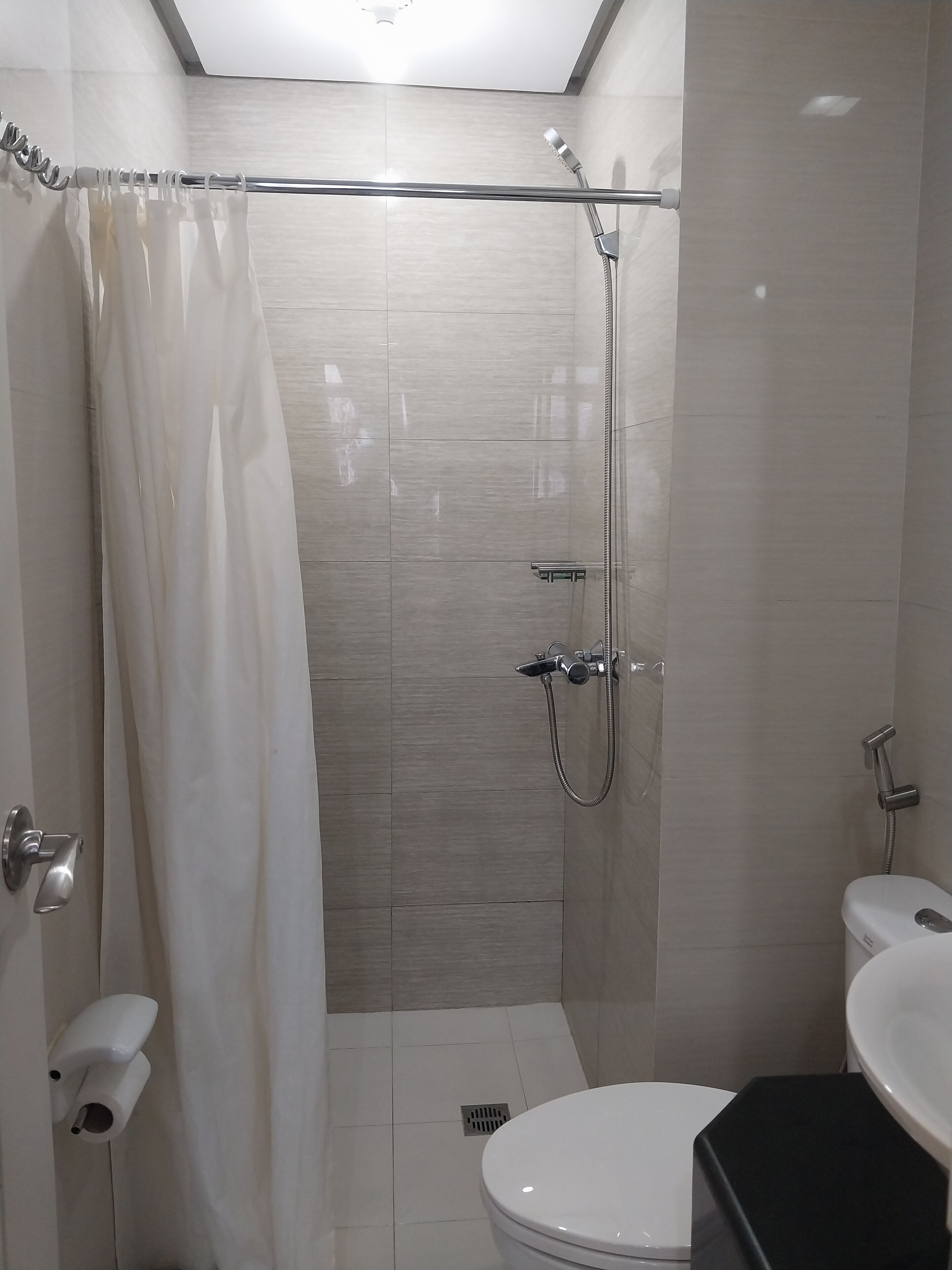 Une salle de bain moderne équipée d’une douche, de toilettes et d’un lavabo.