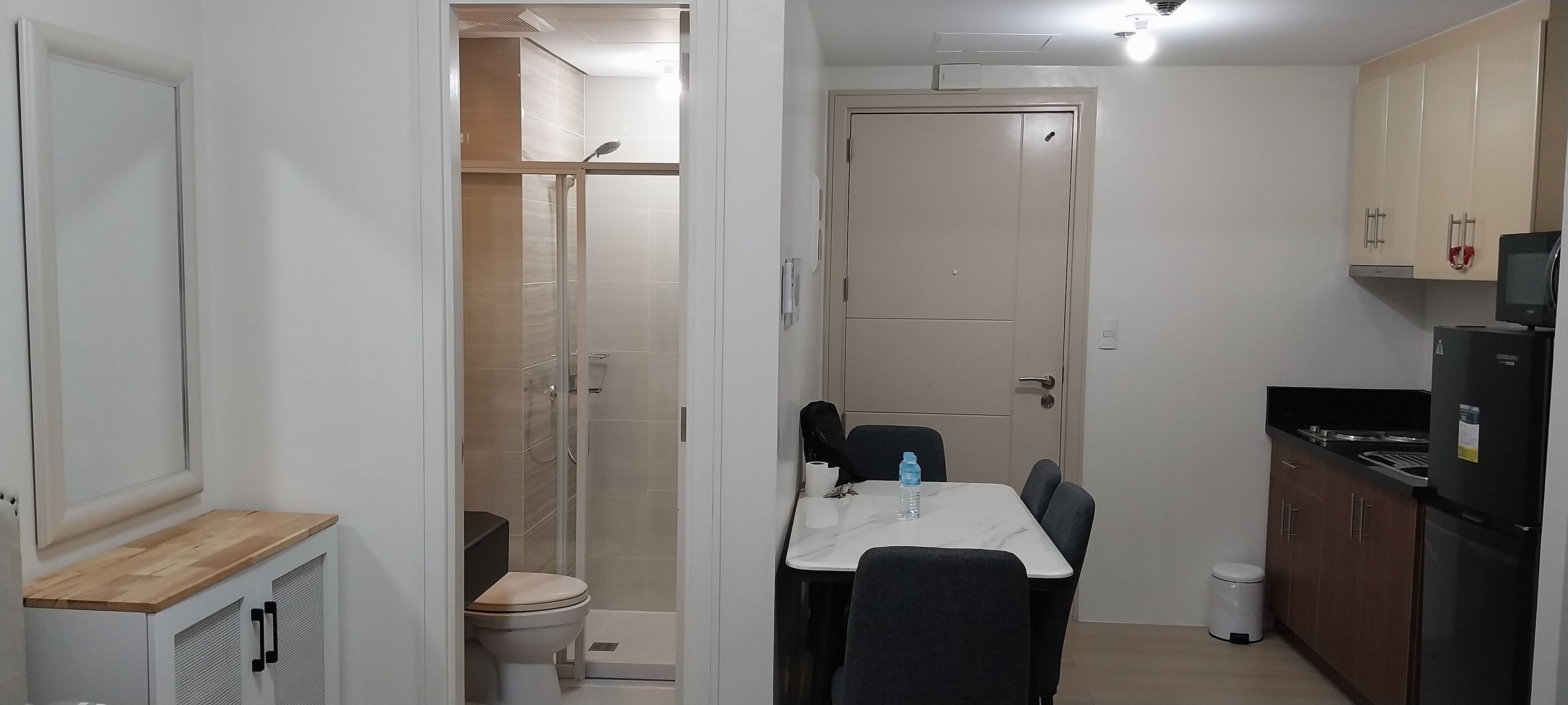 A compact kitchen with a dining area, a built-in oven, and a refrigerator.