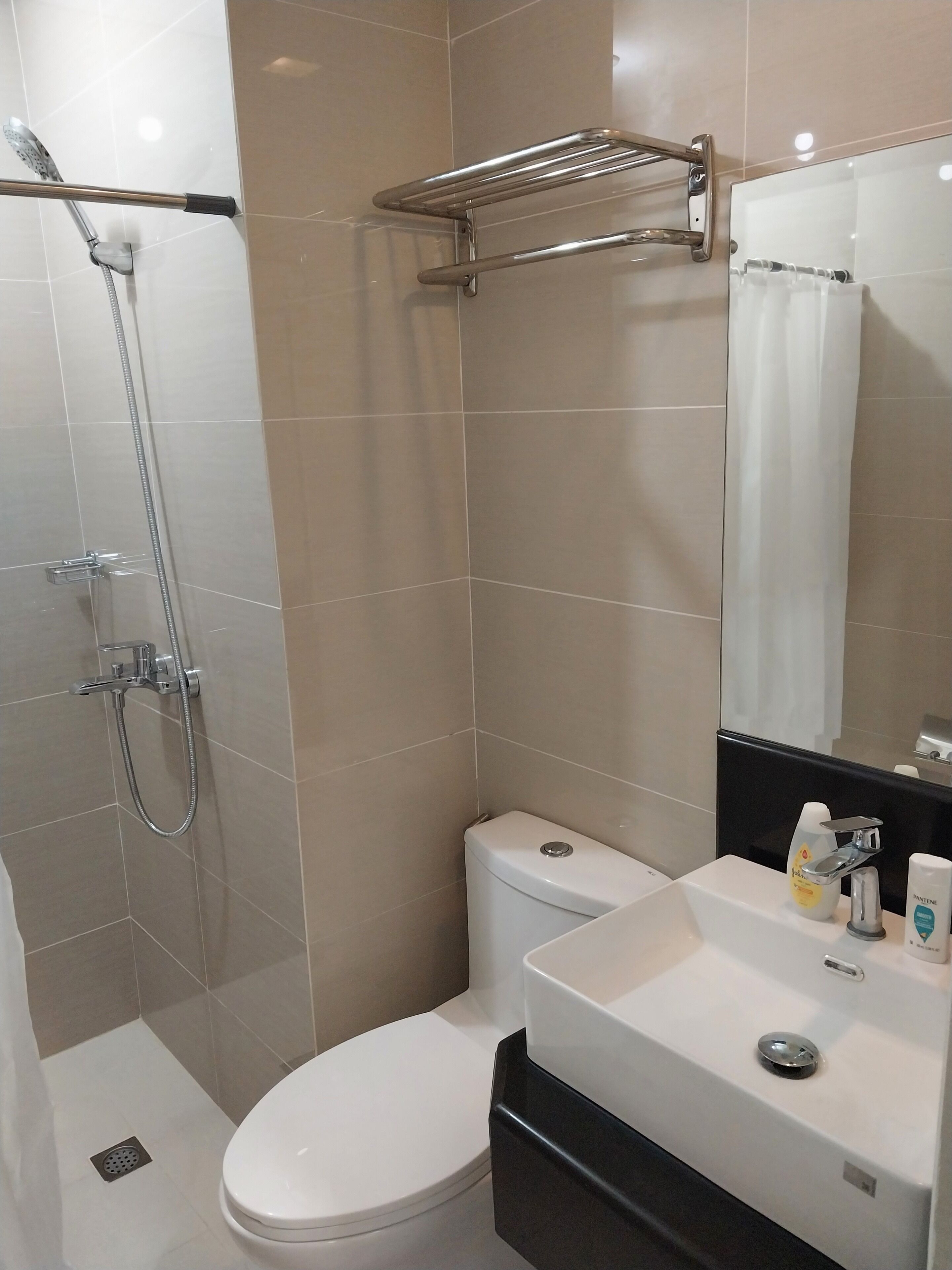 A modern bathroom with a shower, toilet, and sink.