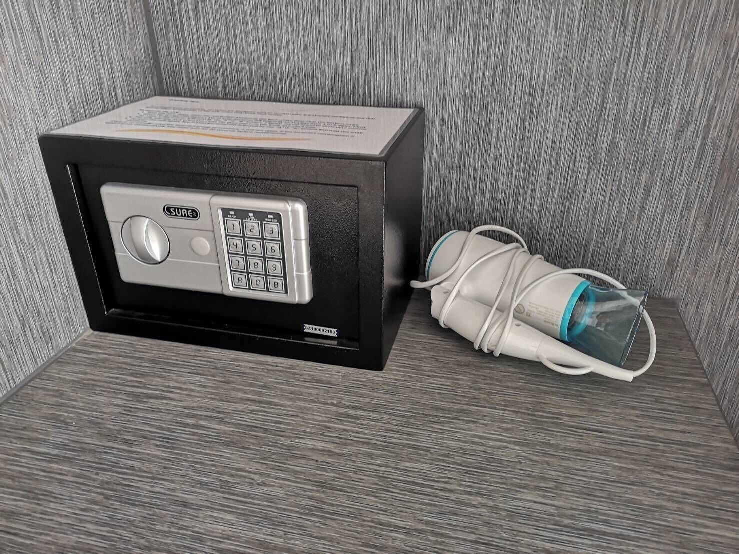 A minibar with a minibar fridge and a water bottle.