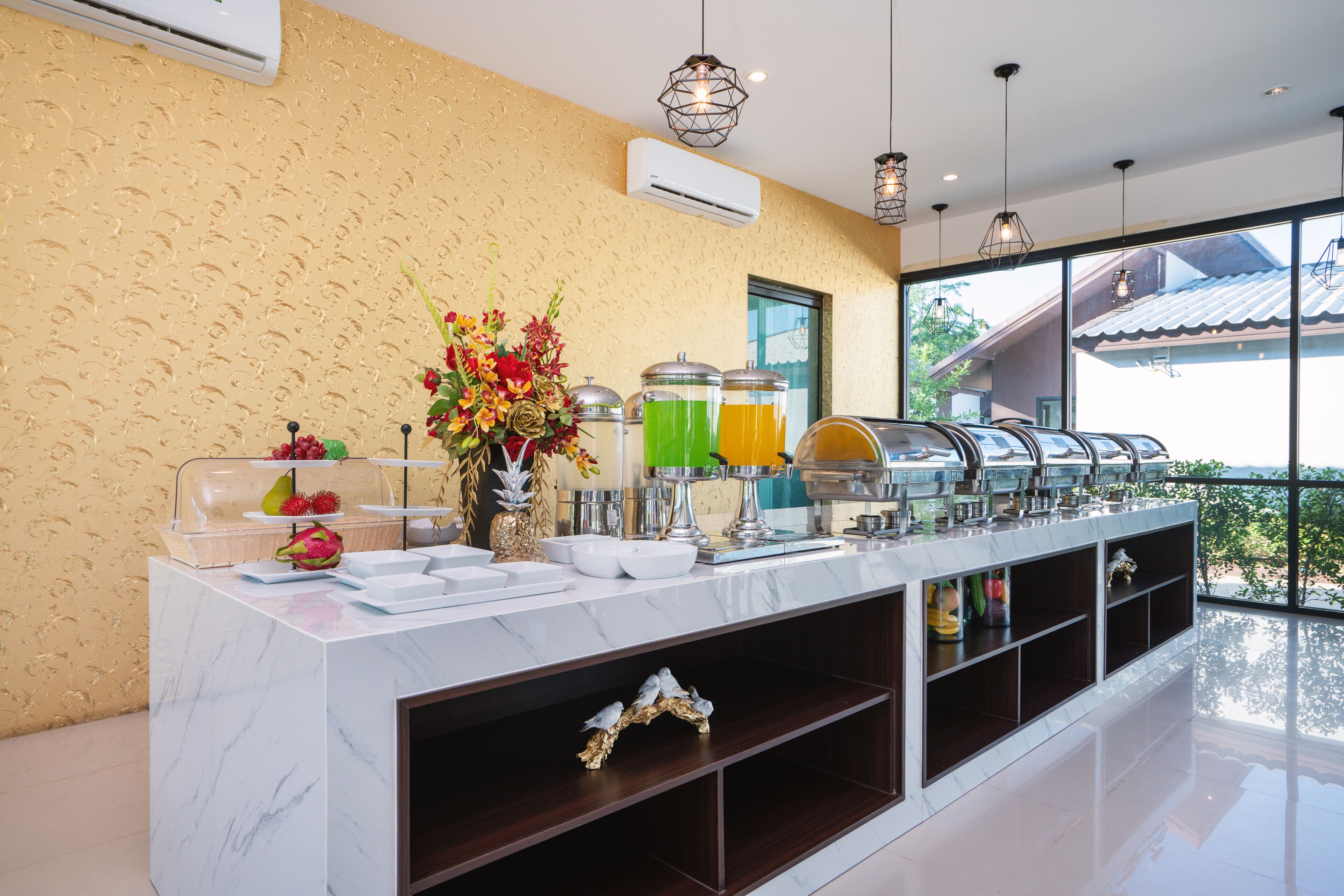 A buffet setup with clear glass containers, a decorative centerpiece, and a view of the outside.