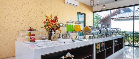 A buffet setup with clear glass containers, a decorative centerpiece, and a view of the outside.