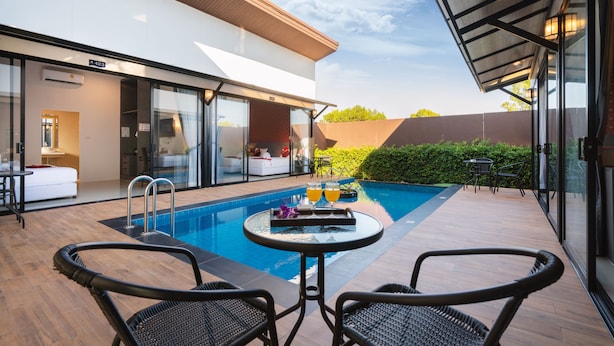 A modern outdoor pool area with a glass-enclosed room, a table with drinks, and wicker chairs. - Thames Tara Private Pool Villa Rawai Phuket (Rawai)