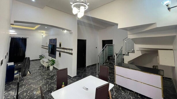 Une chambre d’hôtel moderne dotée d’un coin repas, d’un escalier et d’une télévision.