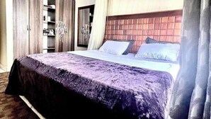 Ein Schlafzimmer mit einem großen Bett, einem Kleiderschrank und einem Spiegel.