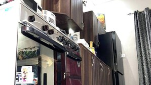 Eine Küche mit Einbauofen, Kühlschrank und Mikrowelle.