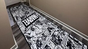 A hallway with a comic strip carpet, a door with a sign, and two wall-mounted posters. - The Comic House (Clinton)