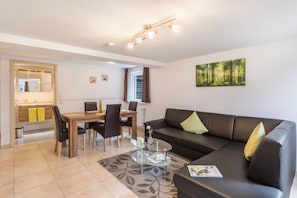 Una sala de estar moderna con un sofá, una mesa de comedor y sillas.