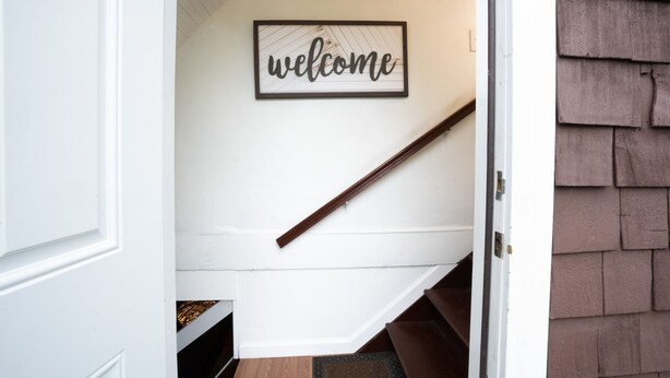Una escalera con barandilla de madera y un cartel que dice 'welcome'.