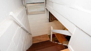 Una escalera con escalones de madera y paredes blancas.