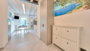 Ein modernes Interieur mit Essbereich, einem weißen Schrank und einem Landschaftsbild.