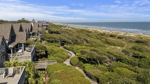 A coastal property with a pathway leading to a beach, surrounded by lush greenery and modern architecture. - AMAZING Ocean Front View! Popular 3BR Seascape Condo! (Kiawah Island)