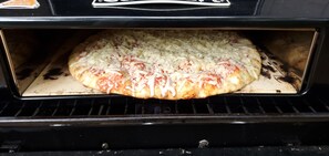 A pizza inside an oven. - Couples Retreat: King Bed:Hot tub:Firepit:Projector & More (Fannin County)