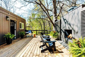 A wooden deck with outdoor seating, a hanging chair, and potted plants. - Couples Retreat: King Bed:Hot tub:Firepit:Projector & More (Fannin County)